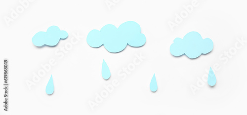 Paper clouds with rain drops on white background. Weather forecast concept