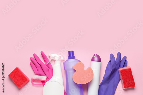 Different cleaning supplies on pink background