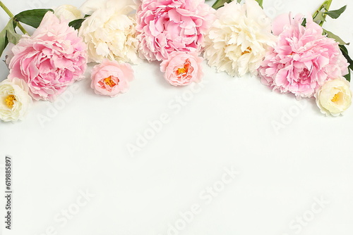 Beautiful peony flowers and roses on a light background, flower arrangement with place for text, summer banner, greeting card for wedding, birthday, template for design, selective focus