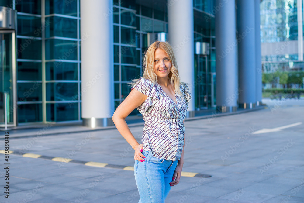 Stylish beautiful blonde walks around the city, great design for any purpose. Attractive elegant woman in jeans.