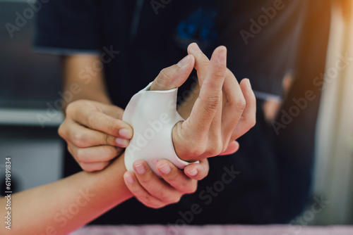 Therapist making asissistive device for immobilize patient hand. Splint service for hand injury rehabilitation of occupational therapy clinic. photo