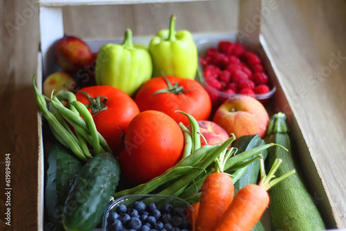 Wooden crate full of healthy seasonal fruit and vegetable. Selective focus, wooden background.