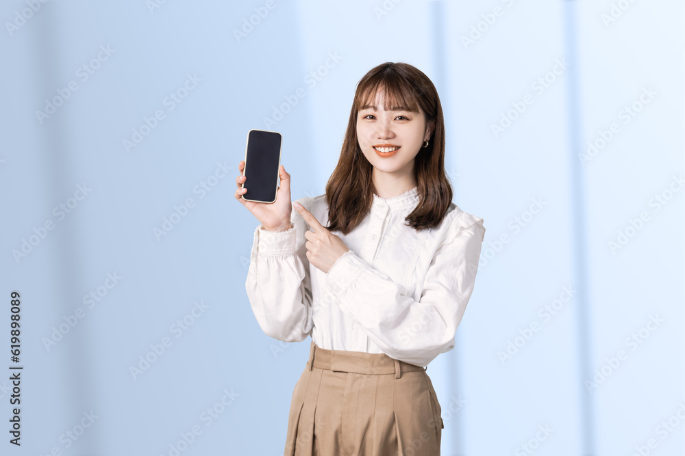 スマホを指差す笑顔のビジネスウーマン