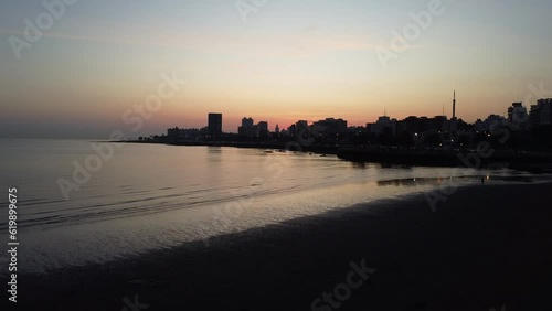 Toma aerea de la ciudad de Montevideo, Uruguay al atardecer donde se ve la playa Ramirez, el Rio de la Plata y la silueta de la ciudad. photo