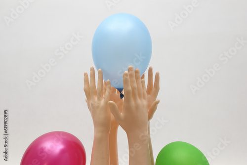 Niebieski balon w rękach manekinów na białym tle.