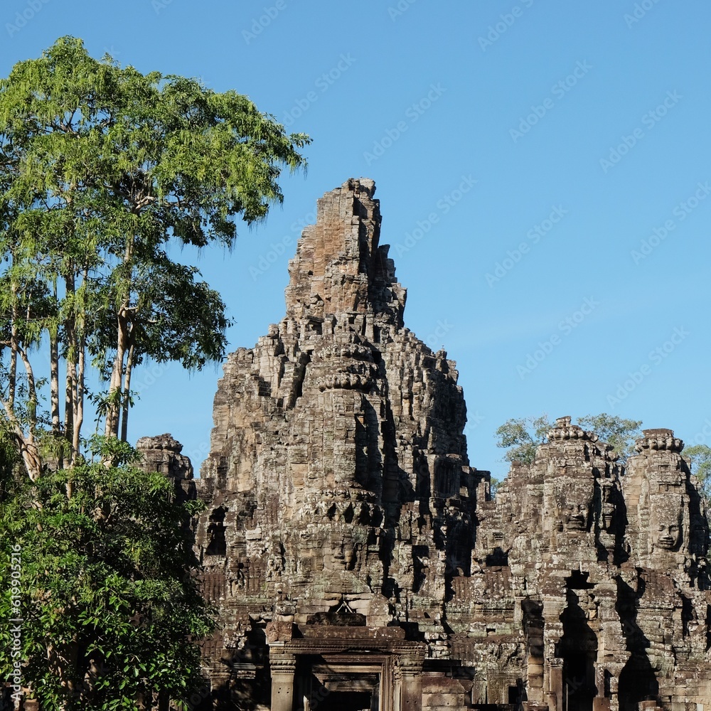 The architecture-rich Bayon Temple in Cambodia, showcased on a sunny, warm day.