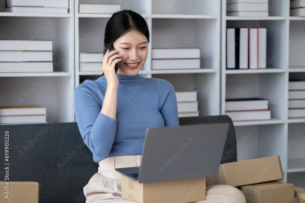Asian woman online store business owner, online shop owner working from home, posting products for sale on website and accepting orders and packing products for customers with private courier service. Asian woman online store business owner, online shop owner working from home, posting products for sale on website and accepting orders and packing products for customers with private courier service.