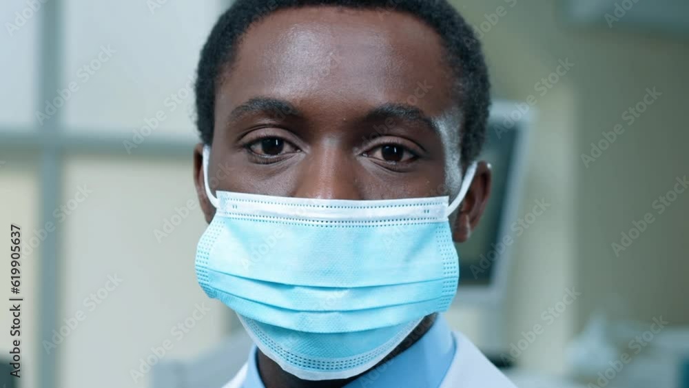 Portrait of African American chemist standing in laboratory. Close up of multicultural male laboratory worker in medical mask. Multiethnic scientist turns head and looking at camera. Portrait of African American chemist standing in laboratory. Close up of multicultural male laboratory worker in medical mask. Multiethnic scientist turns head and looking at camera.