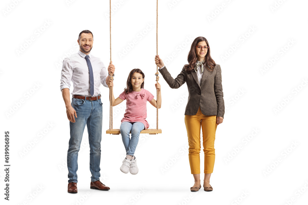 Fototapeta premium Mother and father standing next to their daughter on a swing