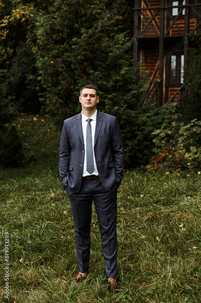 portrait of the groom outside in the autumn season.stylish tall groom in a blue suit.businessman in nature. portrait of a successful man portrait of the groom outside in the autumn season.stylish tall groom in a blue suit.businessman in nature. portrait of a successful man