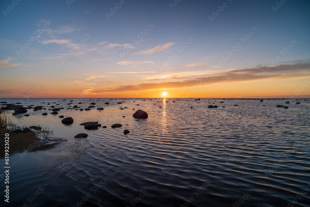 Bright sunset with large yellow sun under the sea surface.