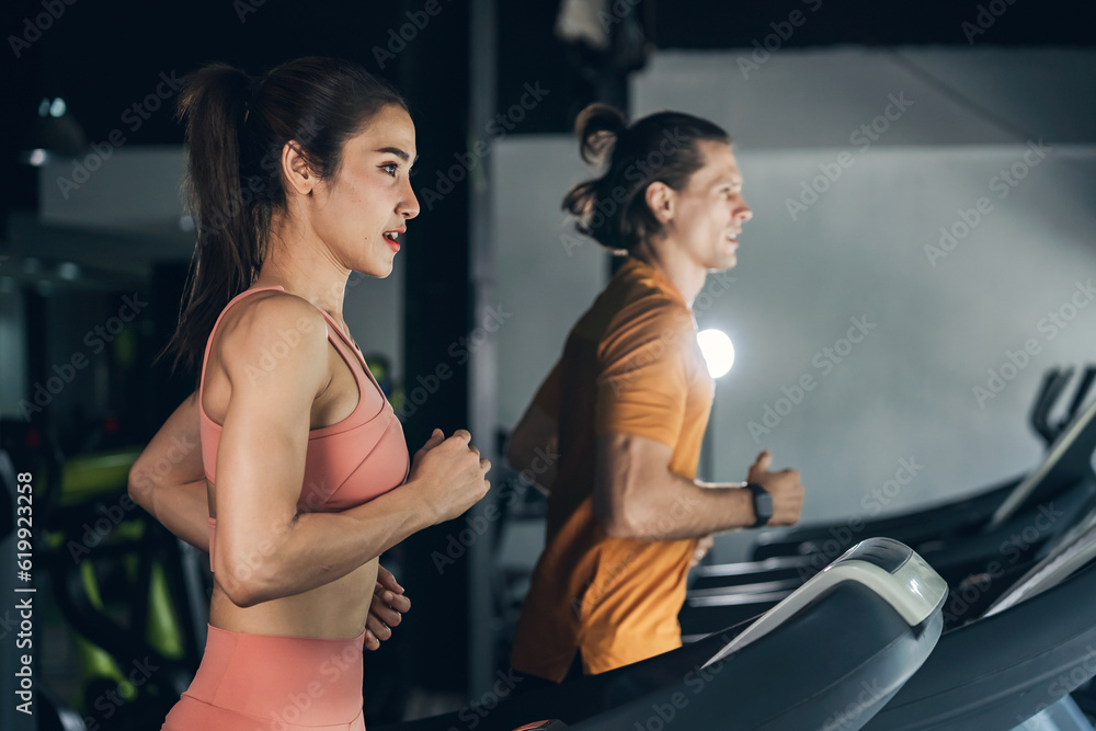 Workout, Fitness workout in gym with trainer assisted in training, Fitness concept, Fit asian woman, Young white man and asian girl exercising in the gym. Workout, Fitness workout in gym with trainer assisted in training, Fitness concept, Fit asian woman, Young white man and asian girl exercising in the gym.