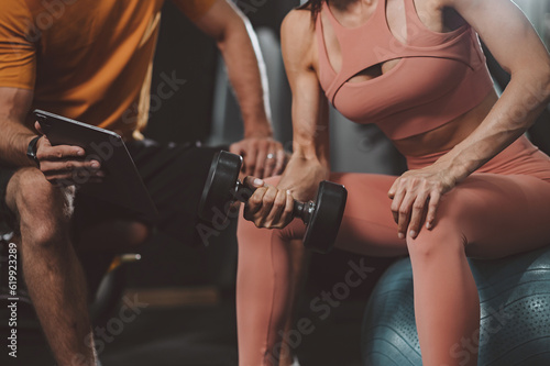 Workout, Fitness workout in gym with trainer assisted in training, Fitness concept, Fit asian woman, Young white man and asian girl exercising in the gym.