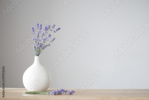 lavender flowers in ceramic vase on gray background
