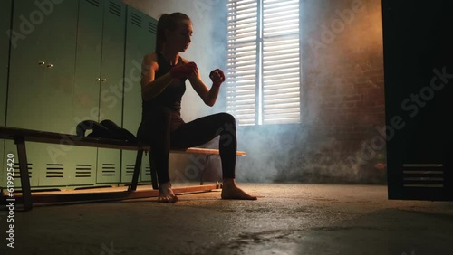 Wallpaper Mural Women self defense girl power. Strong woman fighter punching with red boxing wraps sports protective bandages. Girl punching training punches looking concentrated straight. Fit body workout Torontodigital.ca