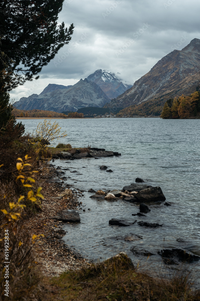 View of the landscape of the Swiss Alps, from the shore of the Sils Lake, during a cloudy autumnal day