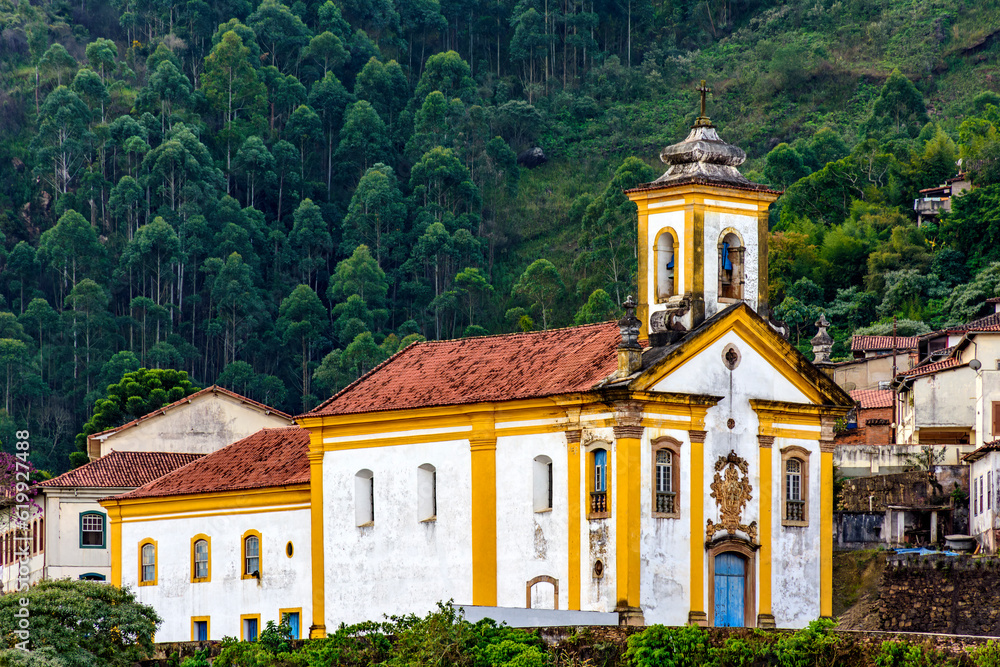 Baroque church and houses in front of the forest in the historic city of Ouro Preto in Minas Gerais