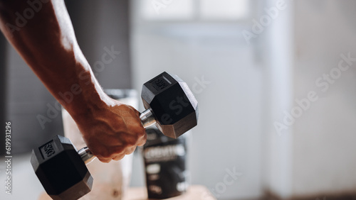 Athletico Man exercising at home. Concept of usefulness of sports nutrition.