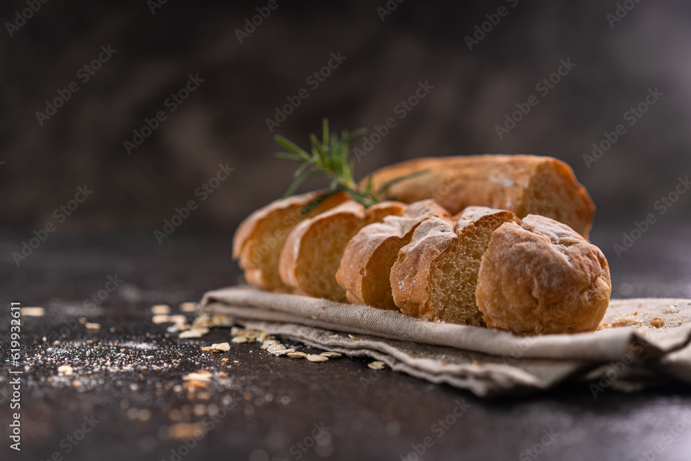 Sliced baguette bread on wooden coaster and rustic background. Artisan Sourdough bread.