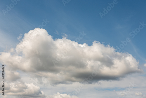 White clouds on a summer blue sky in cartoon style for background or wallpaper design. The whiteness of round clouds in a blue sky. High clouds in the sky.