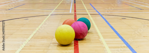 groupe de ballons colorés en caoutchouc sur le sol en bois d'un gymnase intérieur