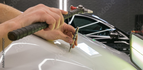 Cuadro en lienzo A specialist repairs a dent on the car body without painting