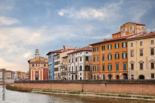 Pisa, Tuscany, Italy: landscape of the Arno river bank Lungarno with colorful ancient buildings and church