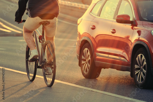 A man on a bicycle rides along the bike path at sunset. Evening bike ride.