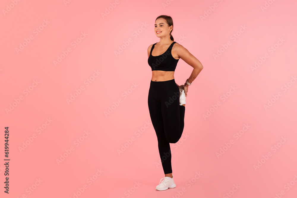 Sporty Lifestyle. Beautiful Fit Woman Stretching Leg While Standing On Pink Background