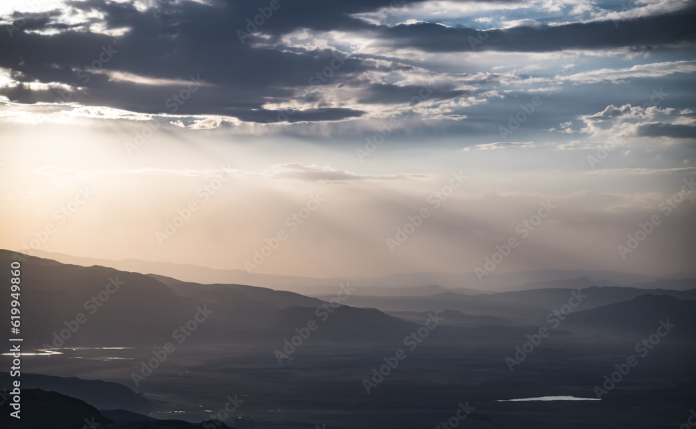 Scenic view from the slopes of the mountain at sunset in the evening with low clouds, evening nature panorama