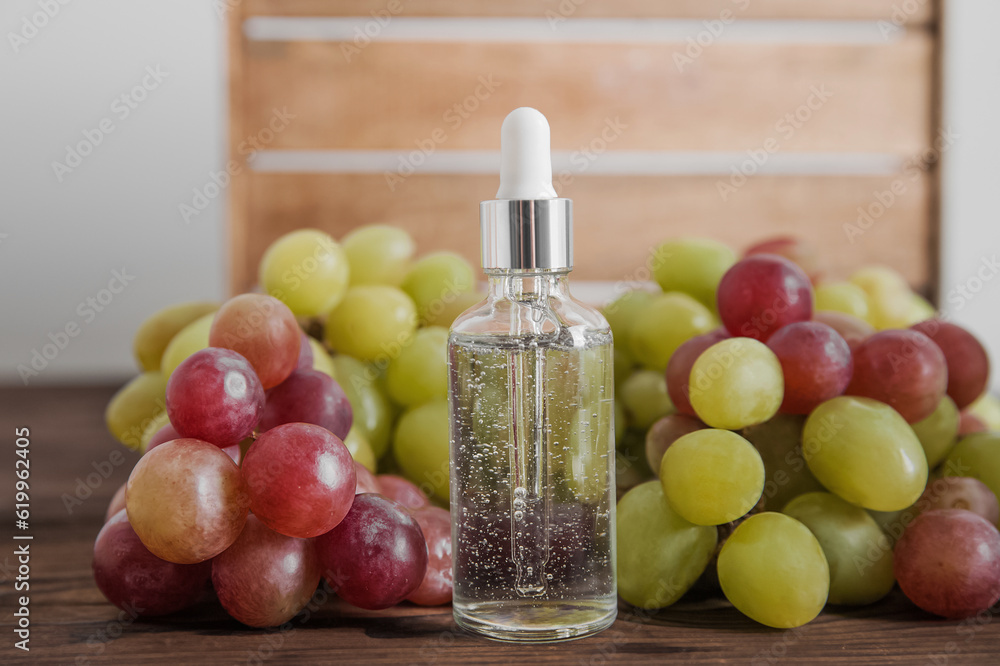 Serum on wooden trending podium and grapes in cut. Skincare, healthcare concept from grape seed oil. Top view. Serum on wooden trending podium and grapes in cut. Skincare, healthcare concept from grape seed oil. Top view.