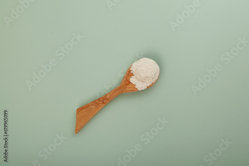 Guar gum powder or guaran. Food additive E412 in wooden spoon. Guar gum often used in Frozen food. Prevent excessive stickiness and Absorption of free water, Control melt down, Freezing point photo