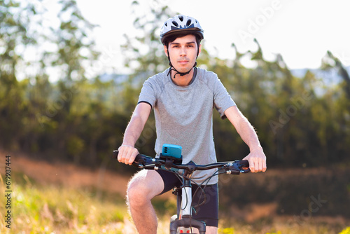 Portrait of a Brazilian cyclist on his mountain bike standing outdoors and looking at the camera.