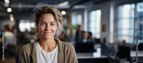 Fotografiet Smiling attractive confident professional woman posing at her business office with her coworkers and employees in the background