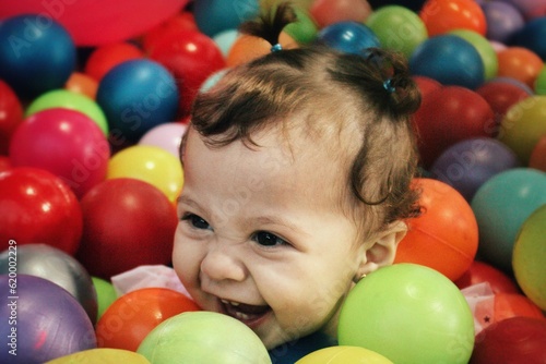Bebé riendo en una piscina de pelotas
