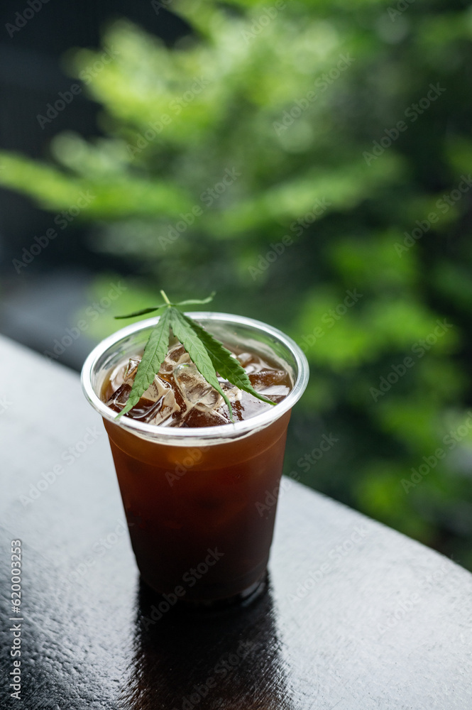 ice coffee with a cannabis leaf on the table ice coffee with a cannabis leaf on the table