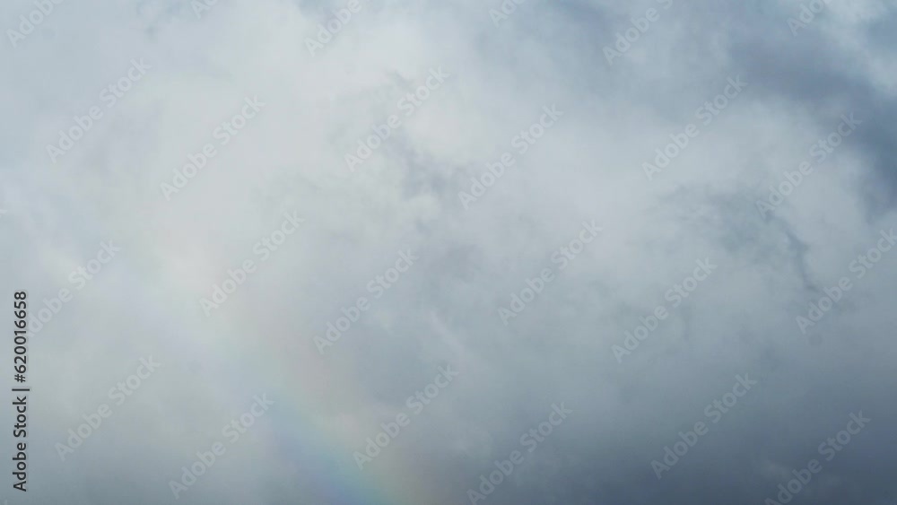 Time lapse of a rainbow appearing and becoming more vivid with clouds moving behind it Time lapse of a rainbow appearing and becoming more vivid with clouds moving behind it