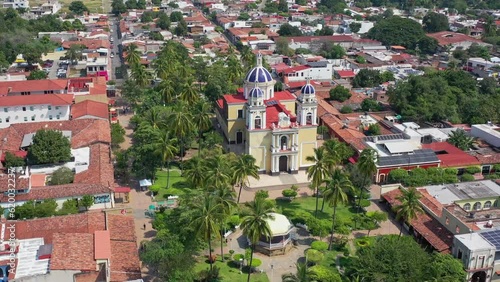 Toma aérea que cruza el jardín central de Villa de Alvarez hasta la Parroquia de San Cristobal de Asis, Colima México. photo