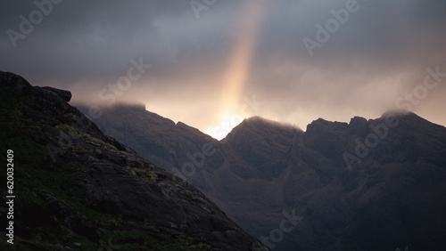 A sun ray illuminating the dramatic landscape of the Cuillin Ridge Mountains on the Isle of Skye, Scotland.