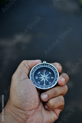 Close-up holding navigation compass outdoor blur background