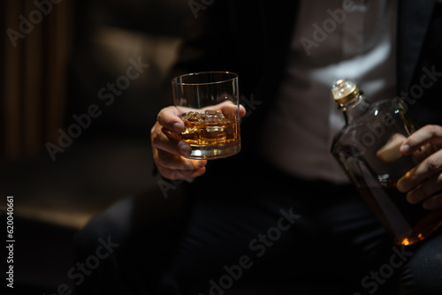 Businessman sitting Holding a Glass of Whiskey Drink Whiskey in the liquor store room