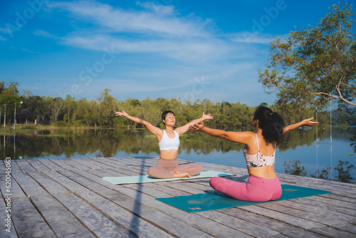 Yoga training for inner balance. Group of diverse women meditating at park, blank space, People doing yoga outdoor, Meditation and sport concept for healthy and relaxing lifestyle with nature field © chokniti