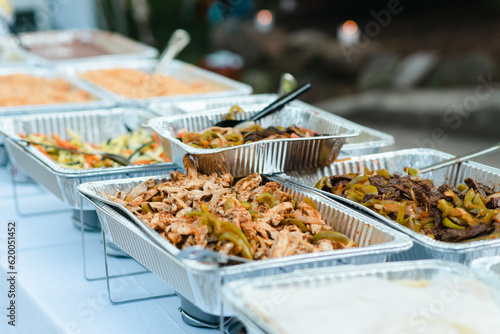 Outdoor catering of fajitas and other Mexican food in aluminum trays