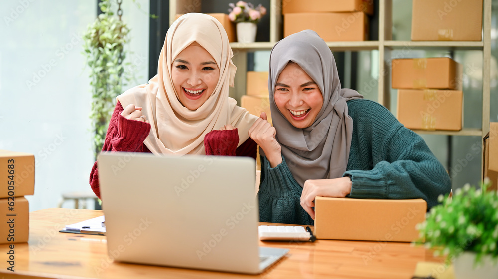 Young Muslim team of online business celebrating together after receiving a big orders. Young Muslim team of online business celebrating together after receiving a big orders.