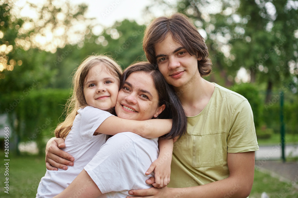 Young adult caucasian beautiful mother enjoy having fun with two cute children outdoors on warm summer day. Family nature outdoor recreation lifestyle. High quality photo