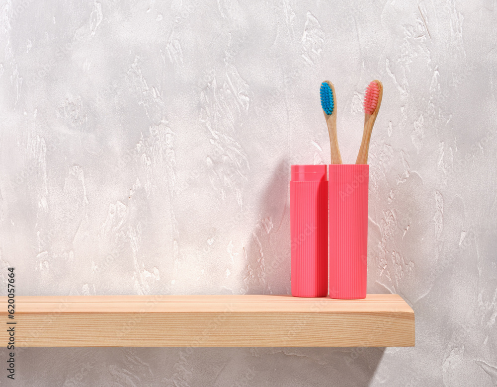 Oral care accessories. Ecological toothbrushes with bristles in different colors in a pink toothbrush container. Copy space for text. Oral care accessories. Ecological toothbrushes with bristles in different colors in a pink toothbrush container. Copy space for text.