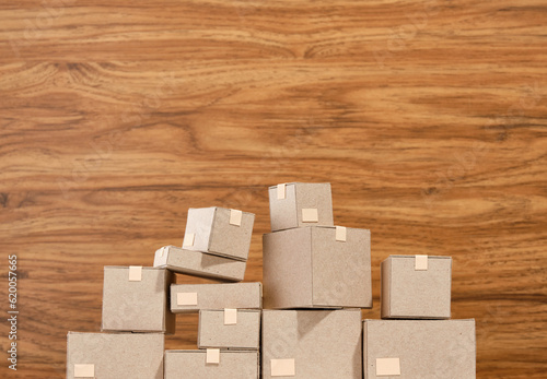 Small and large cardboard boxes with various things on a wooden background. Copy space for text.