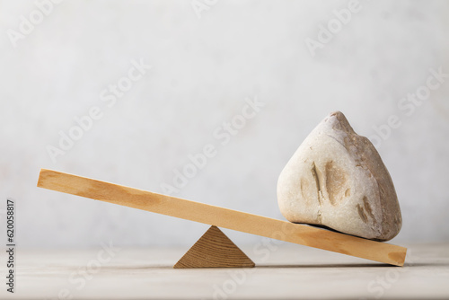 Stone on wooden swing or scales on abstract background, template for designer