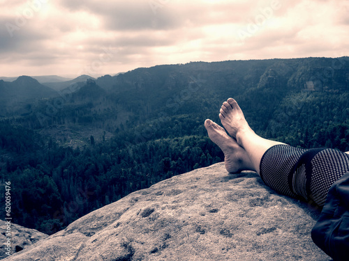Photography Crossed female barefoot legs of man relax on mountain summit
