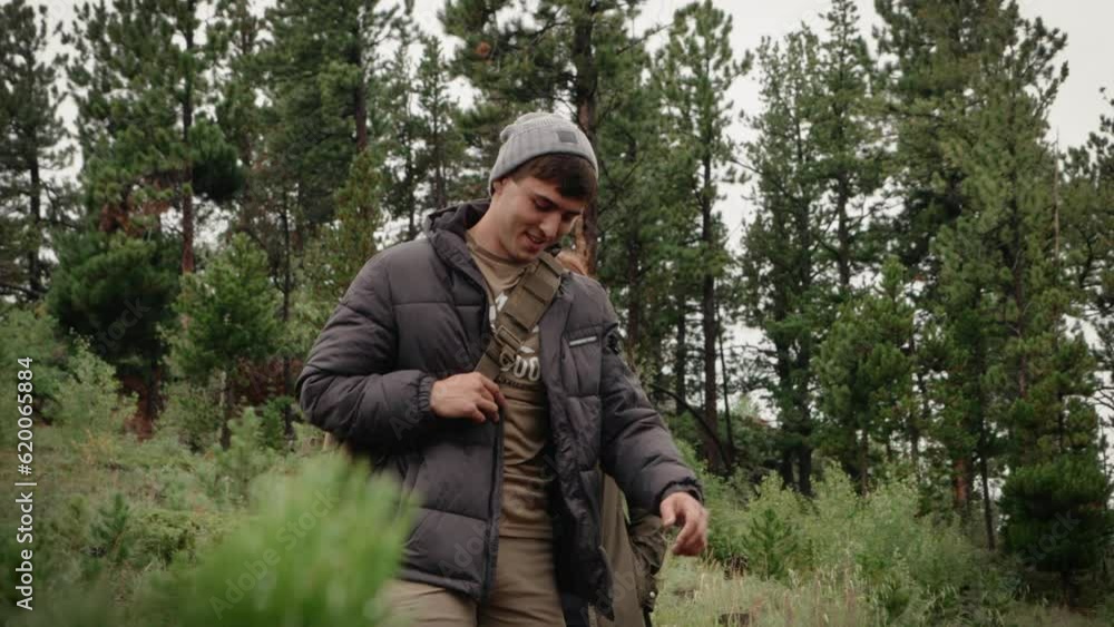 A couple hikes down a mountain forest trail towards the camera. A couple hikes down a mountain forest trail towards the camera.
